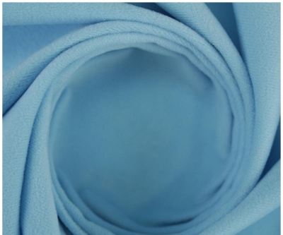 Tecido azul claro enrolado em espiral com textura suave