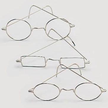 Três pares de óculos metálicos prateados em diferentes formatos sobre fundo branco.