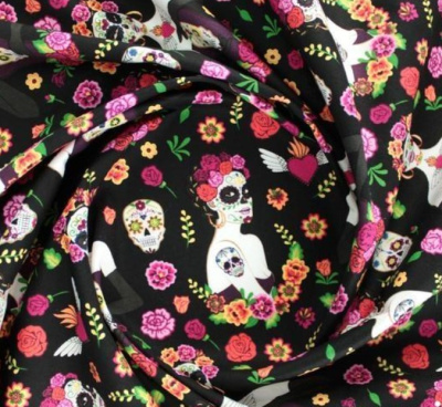 tecido preto com padrão colorido de caveiras mexicanas e flores