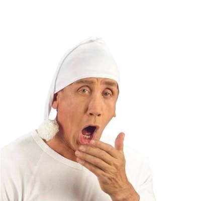 Pessoa com gorro de dormir branco com pompom e camisola branca a bocejar