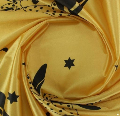 Tecido amarelo com estampado preto enrolado