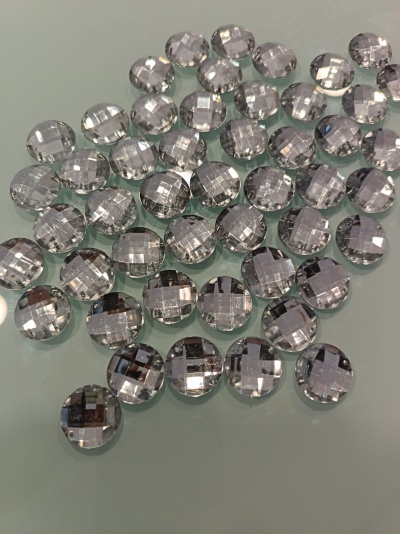 Pedras decorativas transparentes e facetadas sobre superfície cinza claro