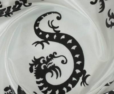 tecido branco com padrão preto de dragão estilizado