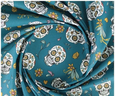 tecido azul com estampado de caveiras mexicanas e flores coloridas