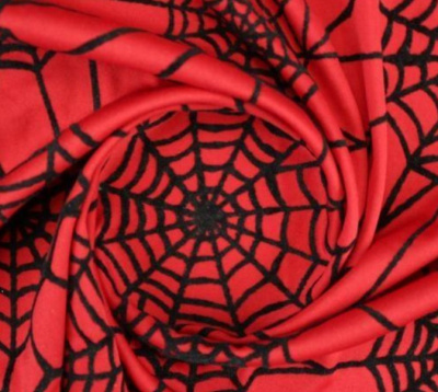 Tecido vermelho com padrão de teias de aranha pretas enrolado