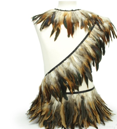 Traje decorativo com penas castanhas, pretas e bege em manequim branco
