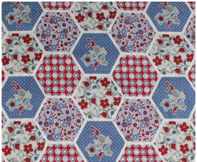 Tecido padrão hexágonos com flores e formas geométricas em azul, vermelho e bege