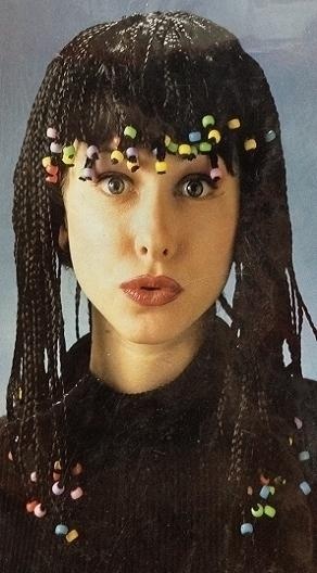 Rapariga com cabelo em tranças finas pretas e contas coloridas