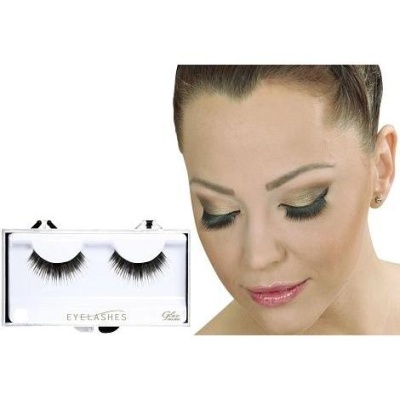 Pestanas falsas pretas e rosto de mulher com maquilhagem dourada