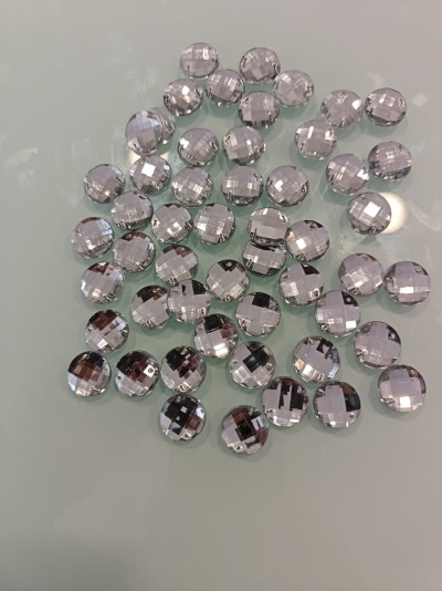 Pequenas gemas transparentes e facetadas sobre superfície clara