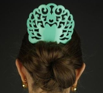 Pente de cabelo verde ornamentado em cabelo castanho preso