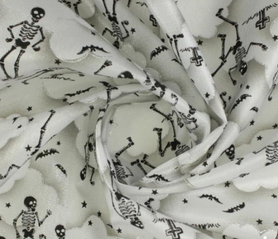 Tecido branco com padrão de esqueletos, morcegos e estrelas em preto