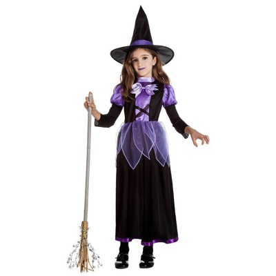 Criança vestida de bruxa com vestido preto e roxo, chapéu pontiagudo, escoba e fundo branco