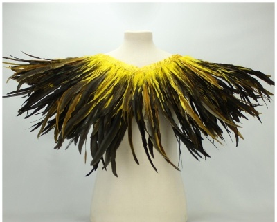 Gola decorativa de penas amarelas e castanhas num manequim