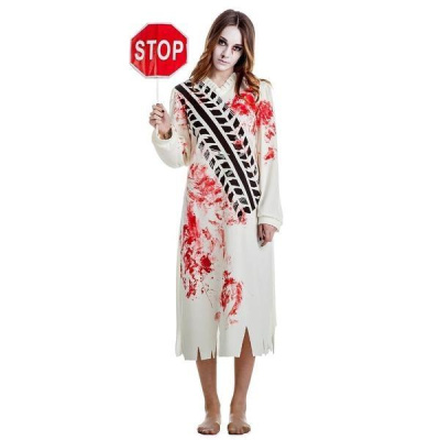 Mulher com vestido longo branco manchado com sangue e pegadas pretas, segurando placa STOP.