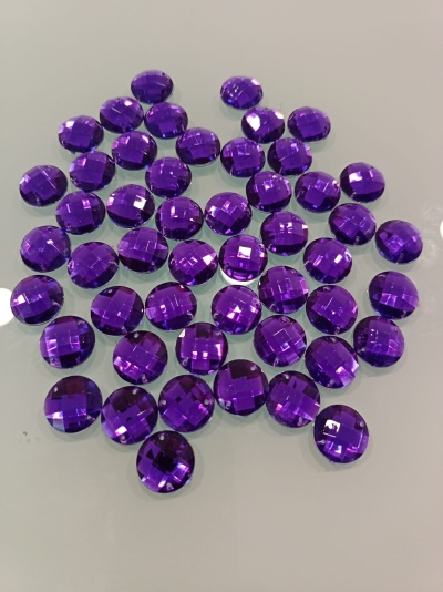 Pedras decorativas roxas redondas e facetadas numa superfície branca