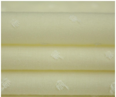 Tecido amarelo claro com padrão branco em relevo