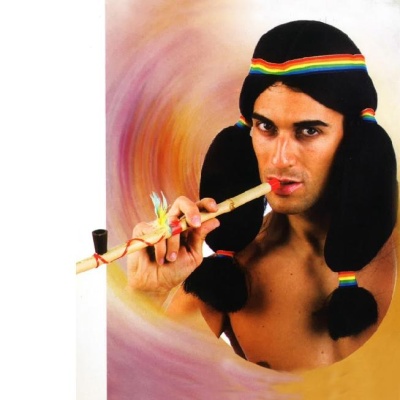 Homem com chapéu preto colorido a tocar flauta de madeira decorada.