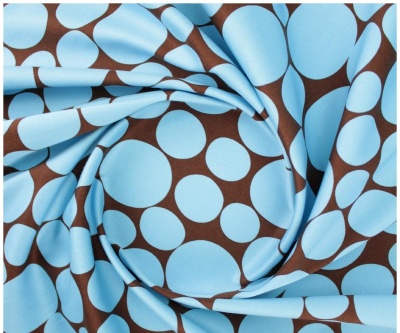 tecido azul com padrão de círculos marrons dobrado
