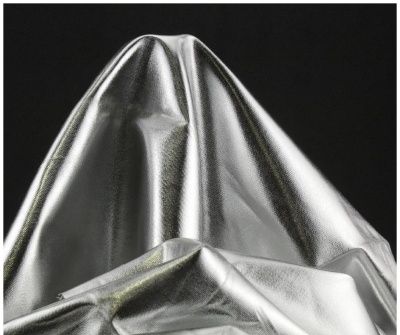 Tecido prateado brilhante com dobras sobre fundo preto