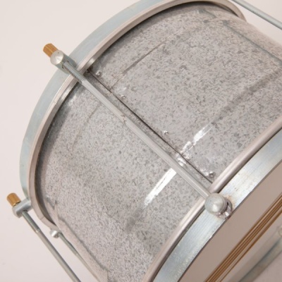 Tambor pequeno de metal cinzento com armações metálicas e detalhes em madeira