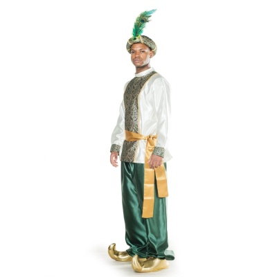 Homem vestido com traje tradicional feminino verde, dourado e branco com penas no barrete.
