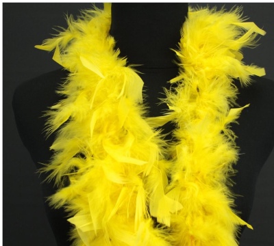 Estola amarela de penas sobre manequim preta em fundo escuro