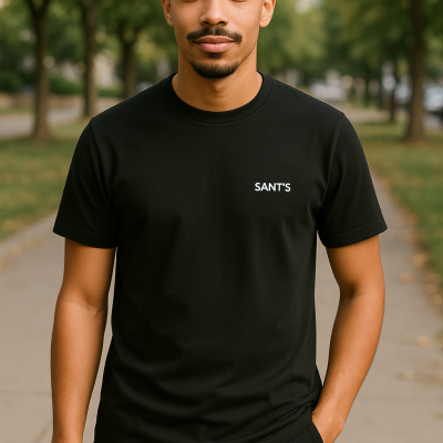 Homem com t-shirt preta com logo branco 'SANT'S' em ambiente exterior com árvores ao fundo