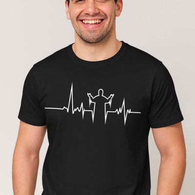 Homem sorridente a usar uma camiseta preta com estampa branca de batimento cardíaco e figura com braços levantados