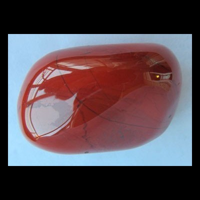 Pedra polida vermelha com linhas pretas finas sobre fundo azul claro