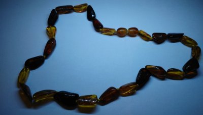 Colar de contas irregulares em tons de âmbar sobre fundo azul