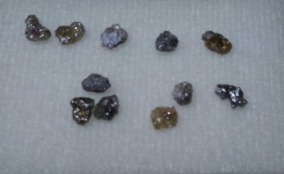 Pedras preciosas brutas de várias cores sobre fundo branco