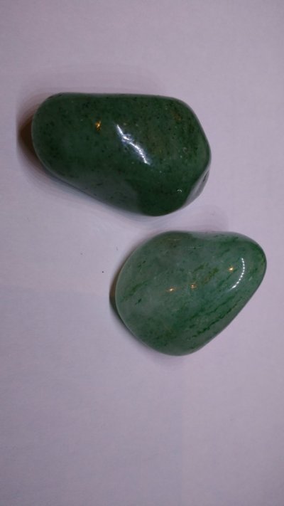Duas pedras verdes polidas sobre fundo branco