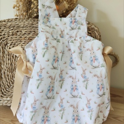 Macacão de bebé branco com padrão de coelhinhos e laços beige