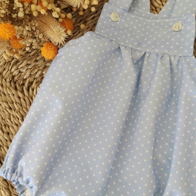 Macacão de bebé azul claro com poás brancos e botões