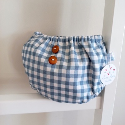 Bolsa pequena em tecido azul e branco com botões castanhos e etiqueta pendurada