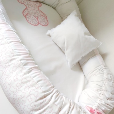 Ninho de bebé branco com padrão rosa e almofada branca