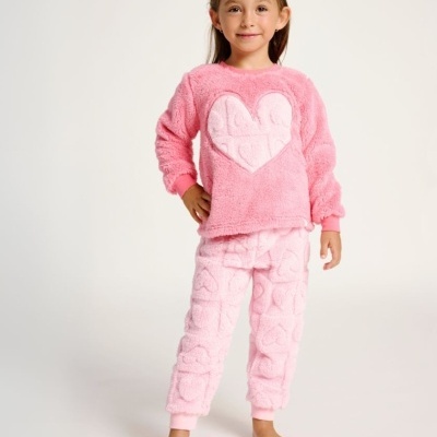Criança vestindo pijama cor-de-rosa felpudo com padrão de corações