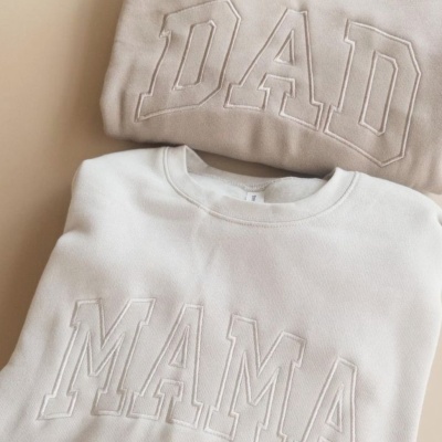 Duas sweatshirts dobradas com palavras DAD e MAMA bordadas