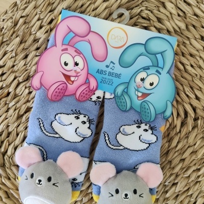 Meias de bebé azuis com estampa de ratinho e aplicação 3D de ratinho cinzento em fundo de embalagem colorida com coelhos cartoon.