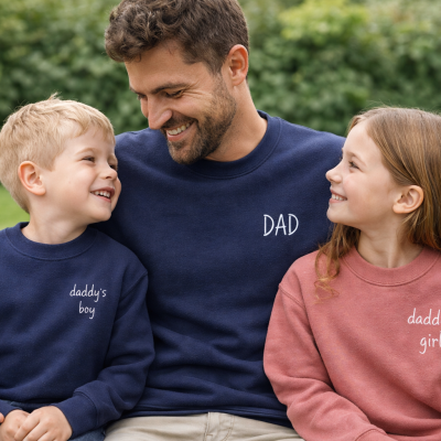 Pai e filhos com camisolas personalizadas azuis e rosa no jardim