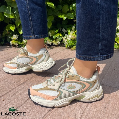 Ténis Lacoste branco, bege, rosa e verde claro com sola grossa usados com jeans ao ar livre
