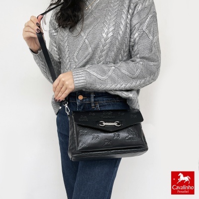 Mala preta em pele com padrão de cavalos em relevo e alça preta