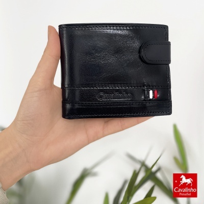 Carteira de pele preta com marca Cavalinho e detalhe colorido, segurada por mão