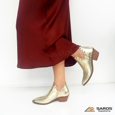 Botins dourados em pele com salto baixo e detalhes em tachas