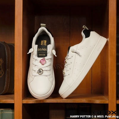 Par de sapatilhas brancas Geox com detalhes Harry Potter numa prateleira de madeira