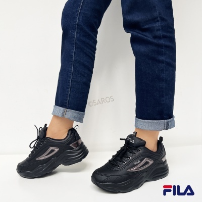 Ténis pretos Fila com detalhes prateados e jeans azul escuro