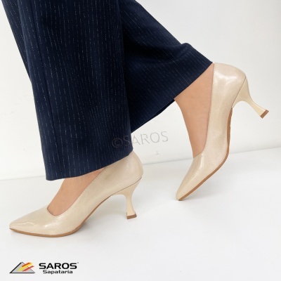 Sapatos de salto médio bege brilhante com calças azul-escuras