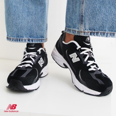 Sapatilhas New Balance pretas e brancas com calças de ganga