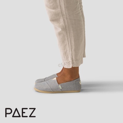 Sapatilhas cinzentas Paez com sola clara e calças bege